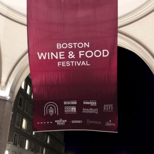 A banner for the Boston Wine & Food Festival, featuring logos of sponsors, hangs under an archway.